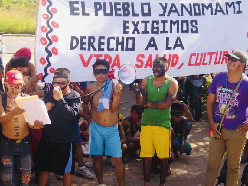 Líderes del pueblo Yanomami exigiendo con megáfono el derecho a la vida, la salud y la cultura en una movilización pública